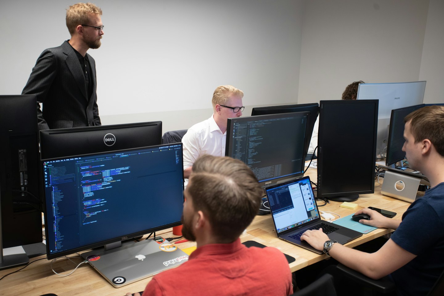 Desarrolladores de software trabajando en estaciones de trabajo informáticas en una oficina moderna.