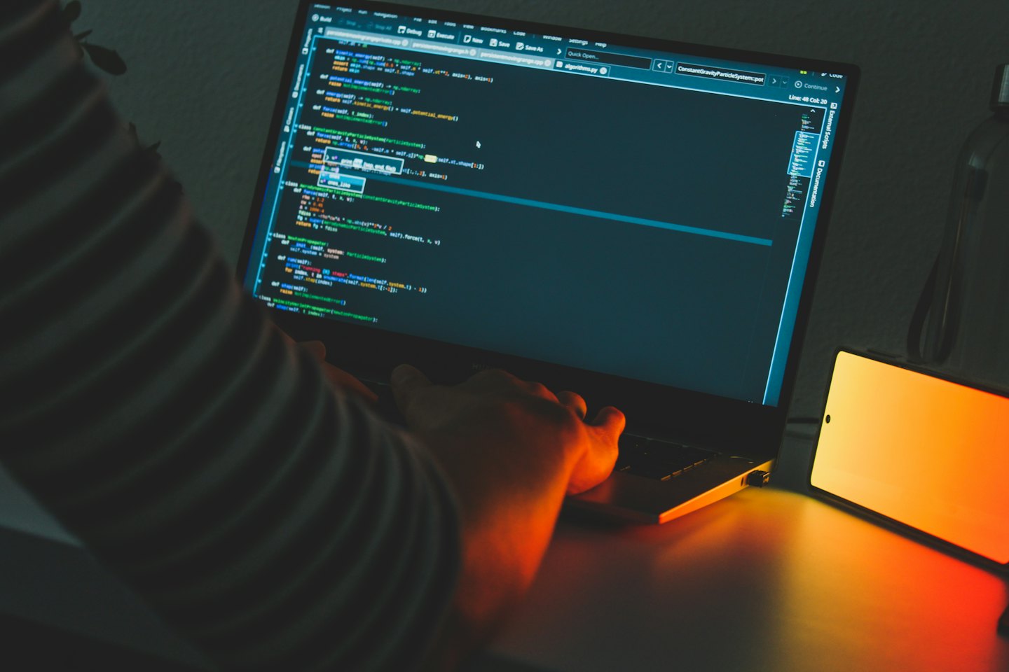 Manos escribiendo código Python en el teclado de un portátil.